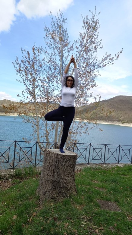 Lucía in posizione dell'albero in riva al lago